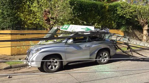 Vehículo resultó completamente aplastado luego que camión derribara postes de luz