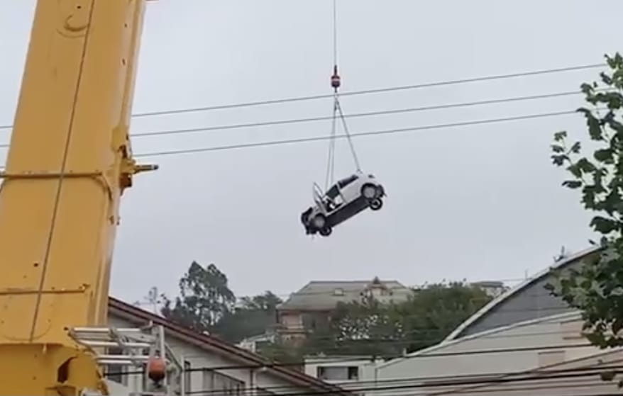 Auto que “voló” al techo de un gimnasio en colegio es retirado con una grúa